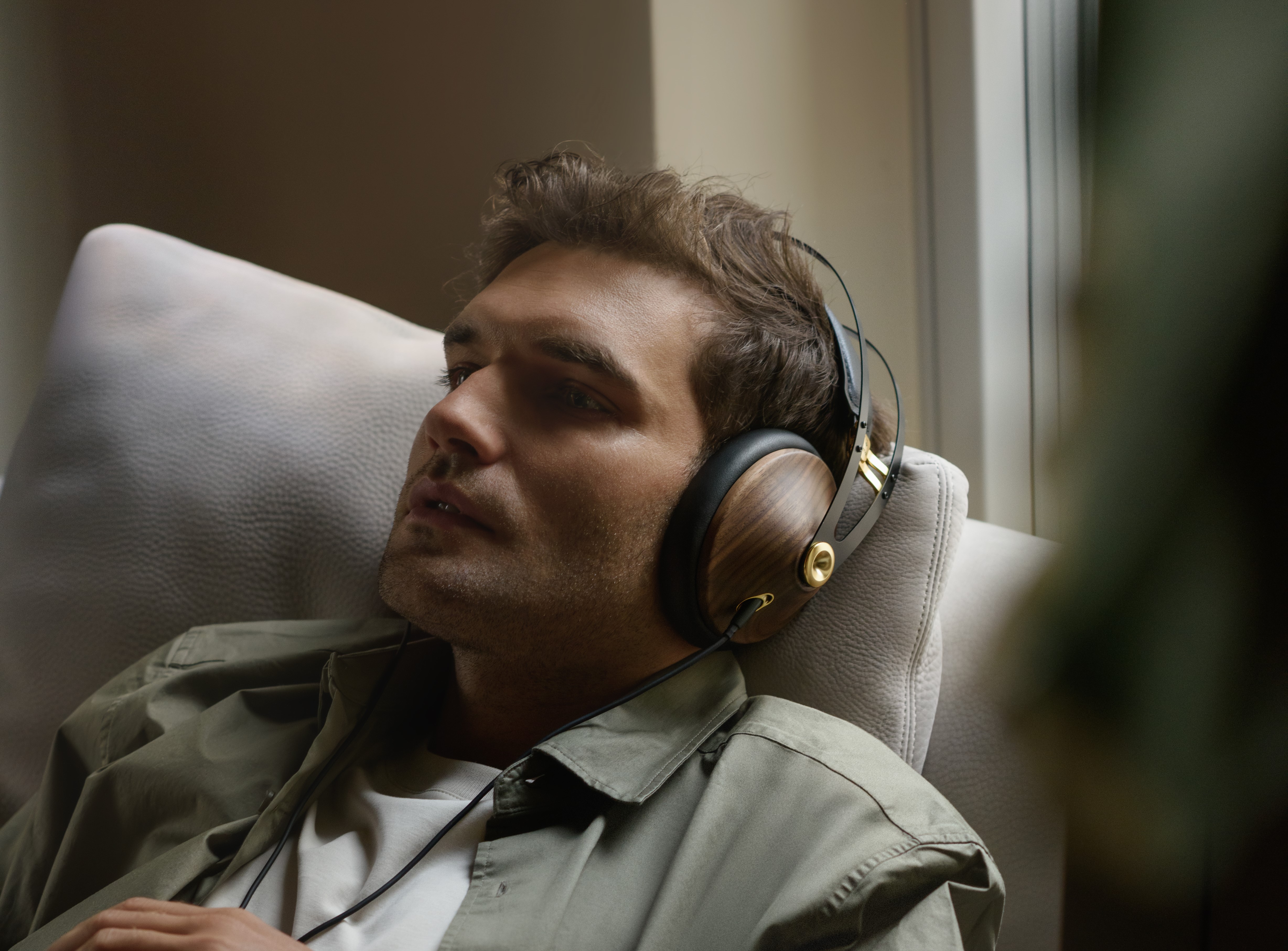 Meze 99 classic 2gen lifestyle bilde, mann nyter musikk i sofaen 