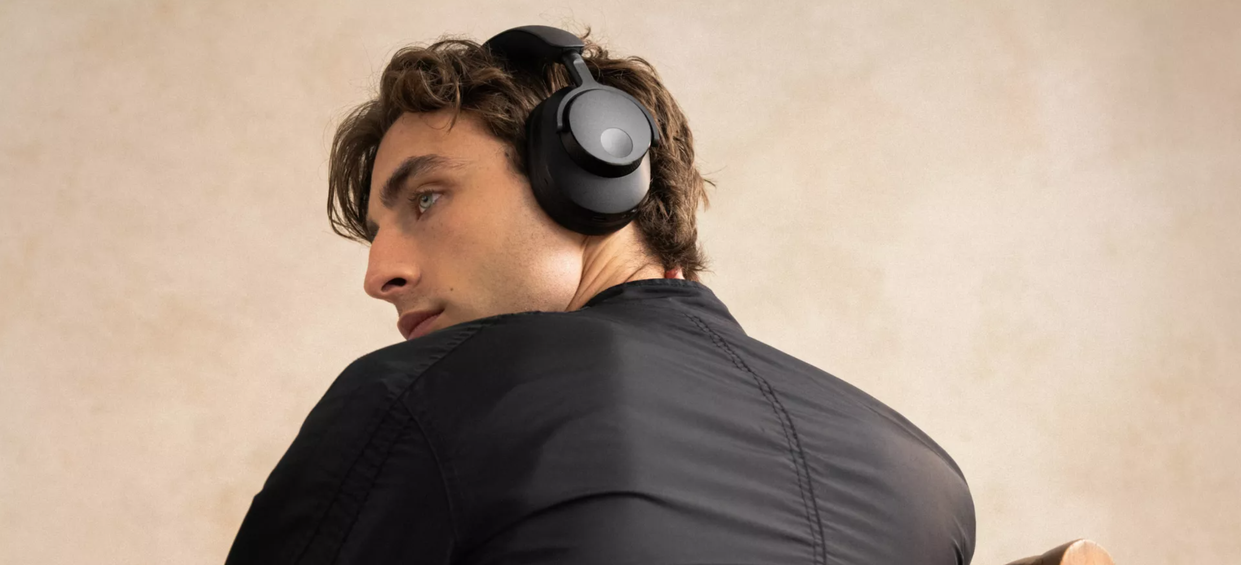 Cambridge Audio Melomania p100 SE lifestyle bilde mann med sorte hodetelefoner trådløse med anc