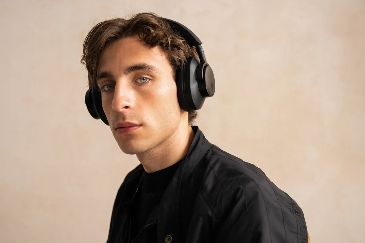 Cambridge Audio Melomania p100 SE  Lifestyle mann har på seg i sort hodetelefoner trådløse med anc