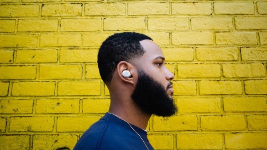 Klipsch T5 II True Wireless ANC man with white earbuds infront of yellow brick wall